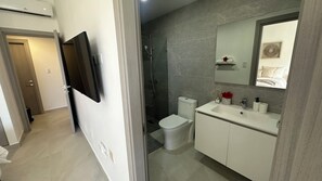 Une salle de bain moderne équipée d’une douche, de toilettes et d’un lavabo.