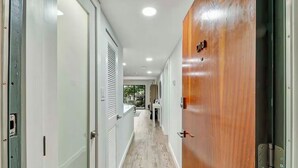 A hallway with a wooden door labeled "18", white walls, and a light-colored floor.