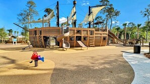 A playground with a pirate ship theme, including slides and a spiral slide.