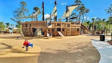 A playground with a pirate ship theme, including slides and a spiral slide.