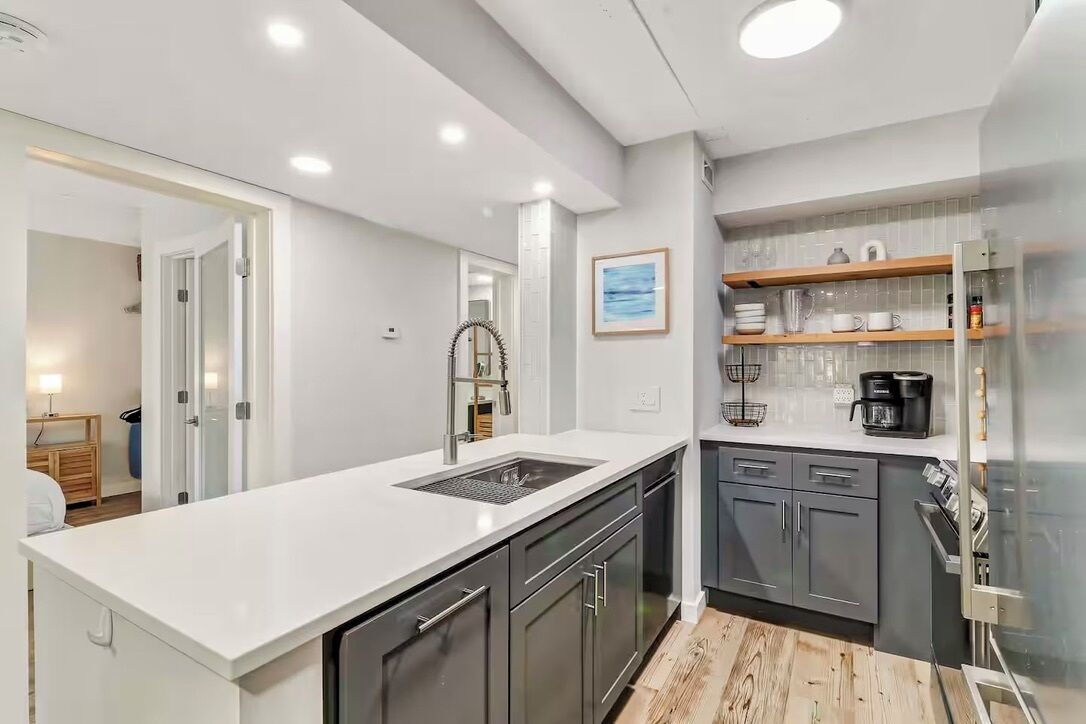 A modern kitchen with a white countertop, dark cabinets, and a built-in oven.