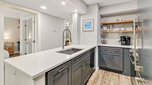 A modern kitchen with a white countertop, dark cabinets, and a built-in oven.