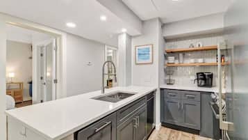 A modern kitchen with a white countertop, dark cabinets, and a built-in oven.