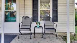 A porch with two metal chairs and a small table with a vase of flowers. - Home < 3 Mi to Rte 66 & Lake Lou Yaeger! (Litchfield)