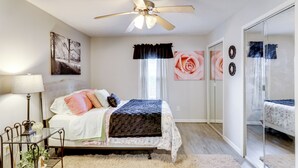 A bedroom with a bed, a ceiling fan, a window with curtains, and a mirror. - Home < 3 Mi to Rte 66 & Lake Lou Yaeger! (Litchfield)