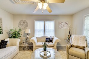 A living room with a beige sofa, a round coffee table, a floor lamp, and a ceiling fan. - Home < 3 Mi to Rte 66 & Lake Lou Yaeger! (Litchfield)