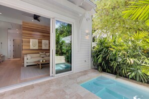 A modern home interior with a living room, a pool, and a garden.