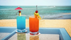 Two drinks on a table with a beach and ocean view. - Ocean Breeze Puerto Vallarta (Puerto Vallarta)