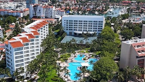 An aerial view of a coastal resort with multiple buildings, a central swimming pool, and a beach area. - Ocean Breeze Puerto Vallarta (Puerto Vallarta)