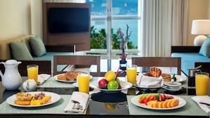 A breakfast table with various dishes, including waffles, fruit, and orange juice, in a hotel room with a view of the sea. - Ocean Breeze Puerto Vallarta (Puerto Vallarta)