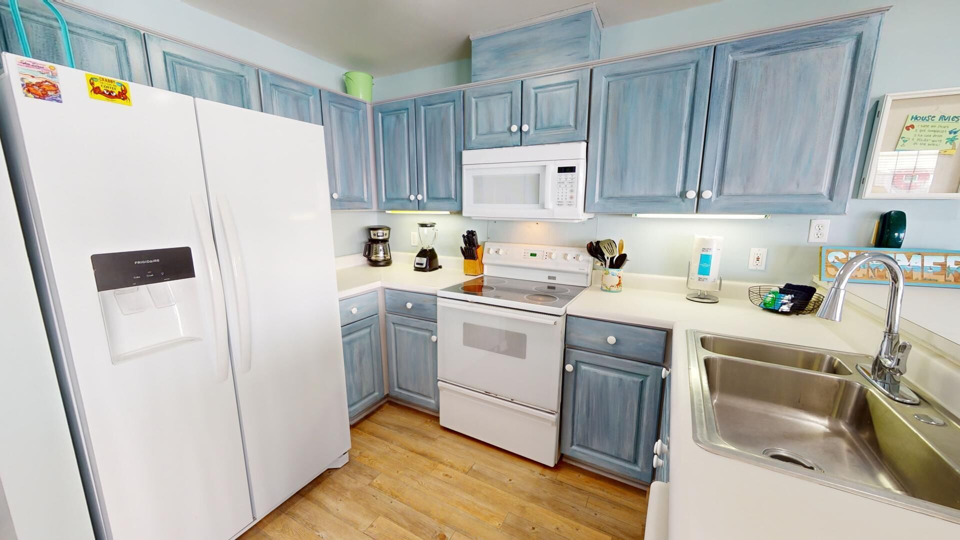 Una cocina compacta con un refrigerador blanco, un microondas, una estufa y un lavamanos.