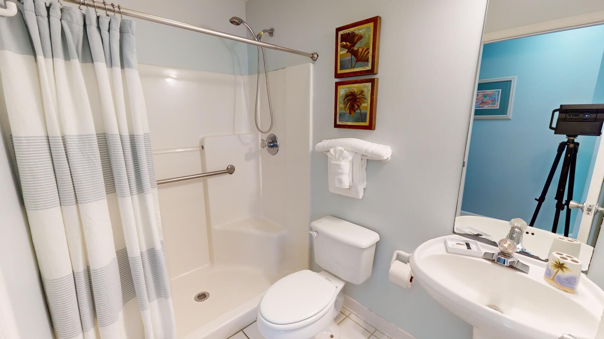 A bathroom with a shower, toilet, and sink.