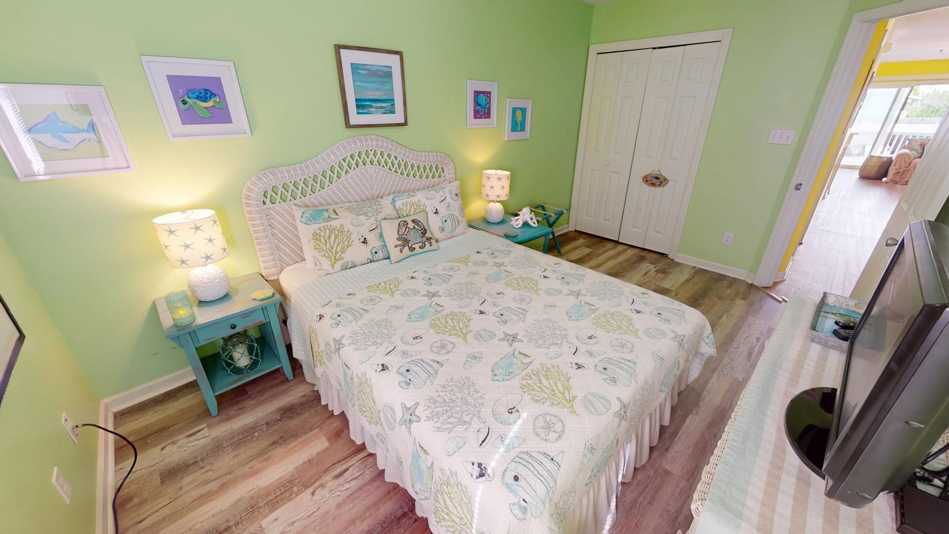A bedroom with a bed, nightstands, a dresser, and a door.