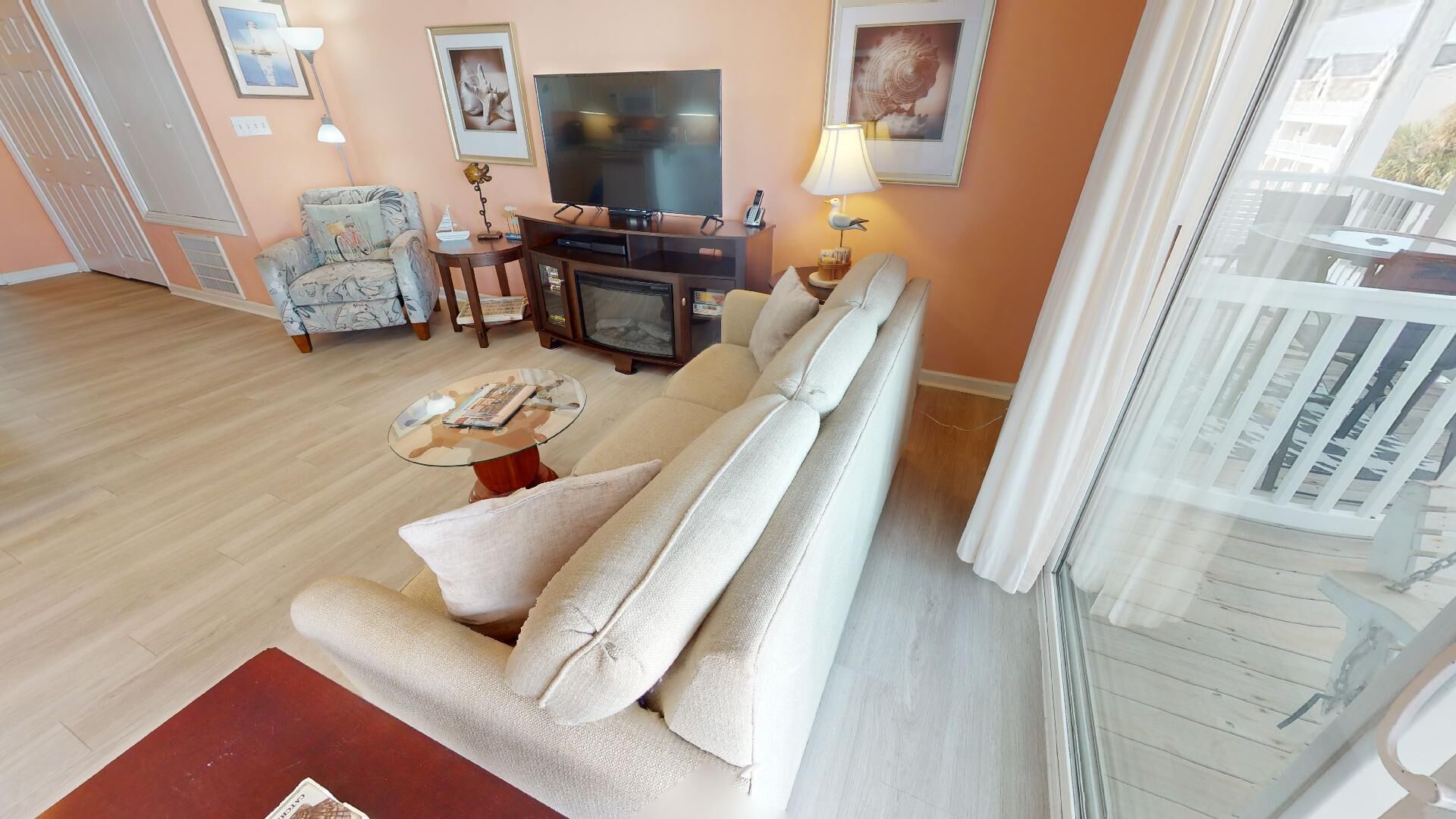 A living room with a sofa, a coffee table, a TV, and a fireplace.