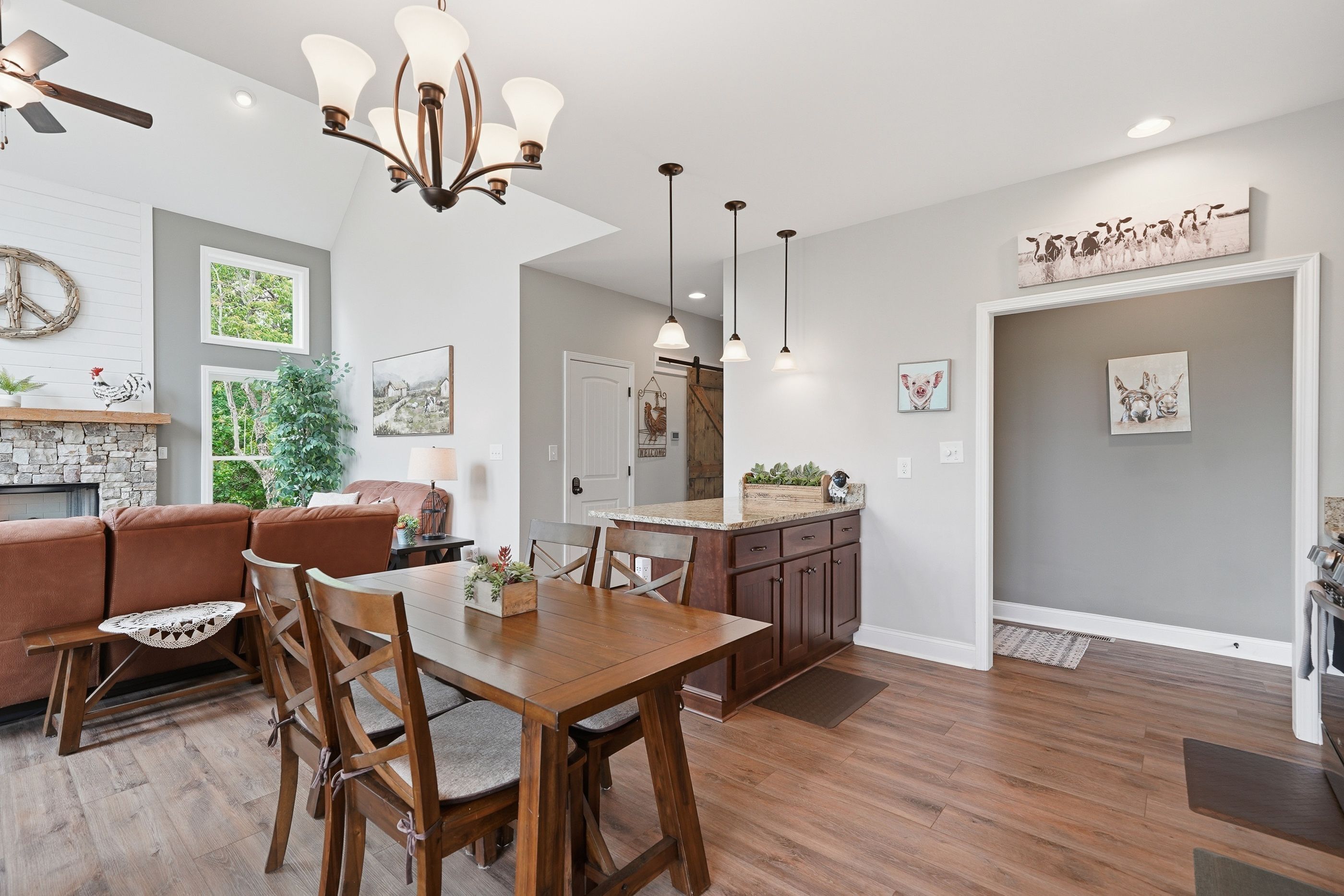 A spacious living area with a wooden dining table, a sofa, and a fireplace.