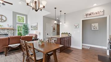 A spacious living area with a wooden dining table, a sofa, and a fireplace.