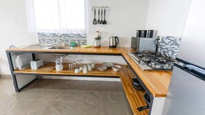 A modern kitchen with a wooden countertop, stainless steel appliances, and a tiled backsplash. - Ocean View House - Monteverde (Sierra)