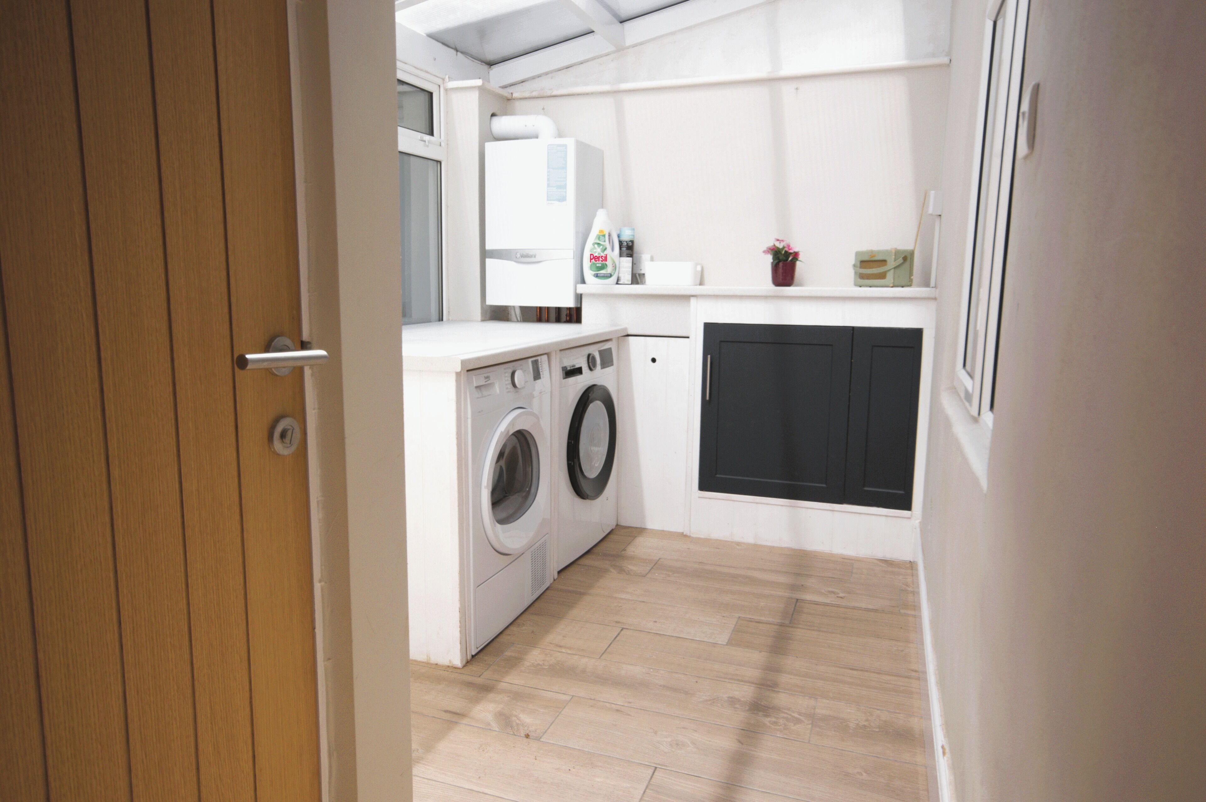 A compact kitchen with a washing machine, a microwave, and a small countertop.