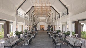 A spacious lobby with a central staircase, seating areas, and a chandelier. - Kahavadi Chiang Rai, Curio Collection By Hilton (Chiang Rai)
