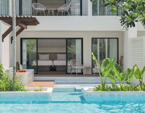 A modern outdoor pool area with a glass-enclosed seating area, a staircase, and a view of the pool.