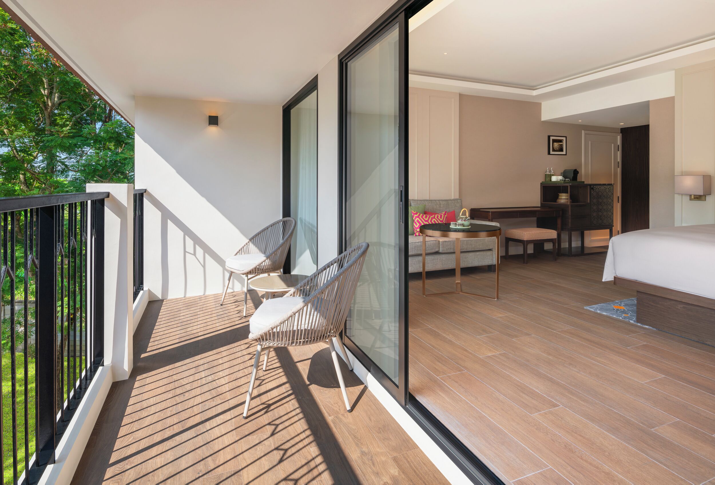 Ein modernes Hotelzimmer mit Balkon, Essbereich und einem großen Bett.