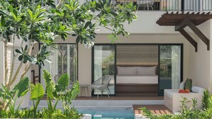 A modern outdoor pool area with a sofa and chairs, surrounded by lush greenery and a clear blue pool. - Kahavadi Chiang Rai, Curio Collection By Hilton (Chiang Rai)