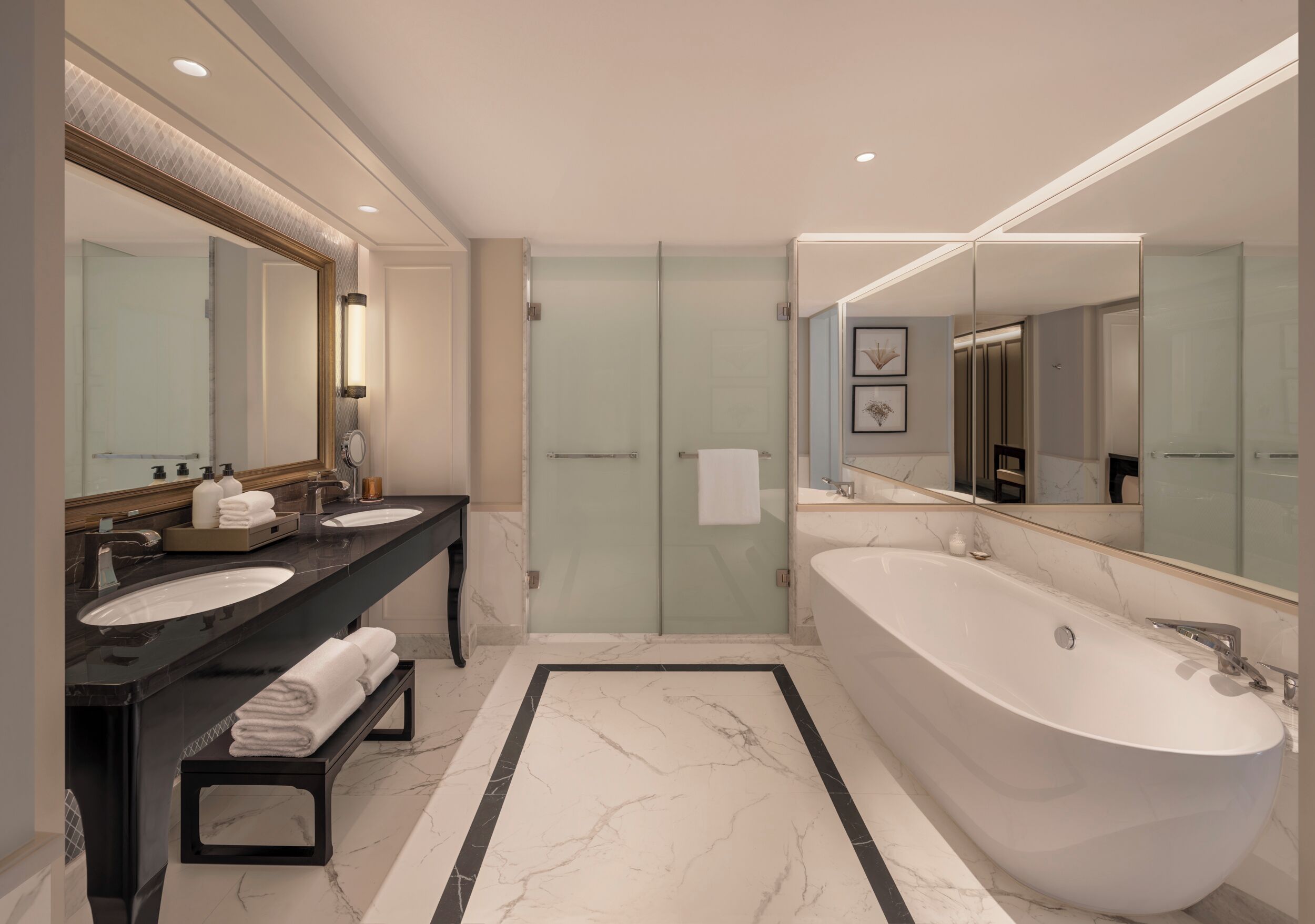 A modern bathroom with two sinks, a large bathtub, and a mirror with a light.