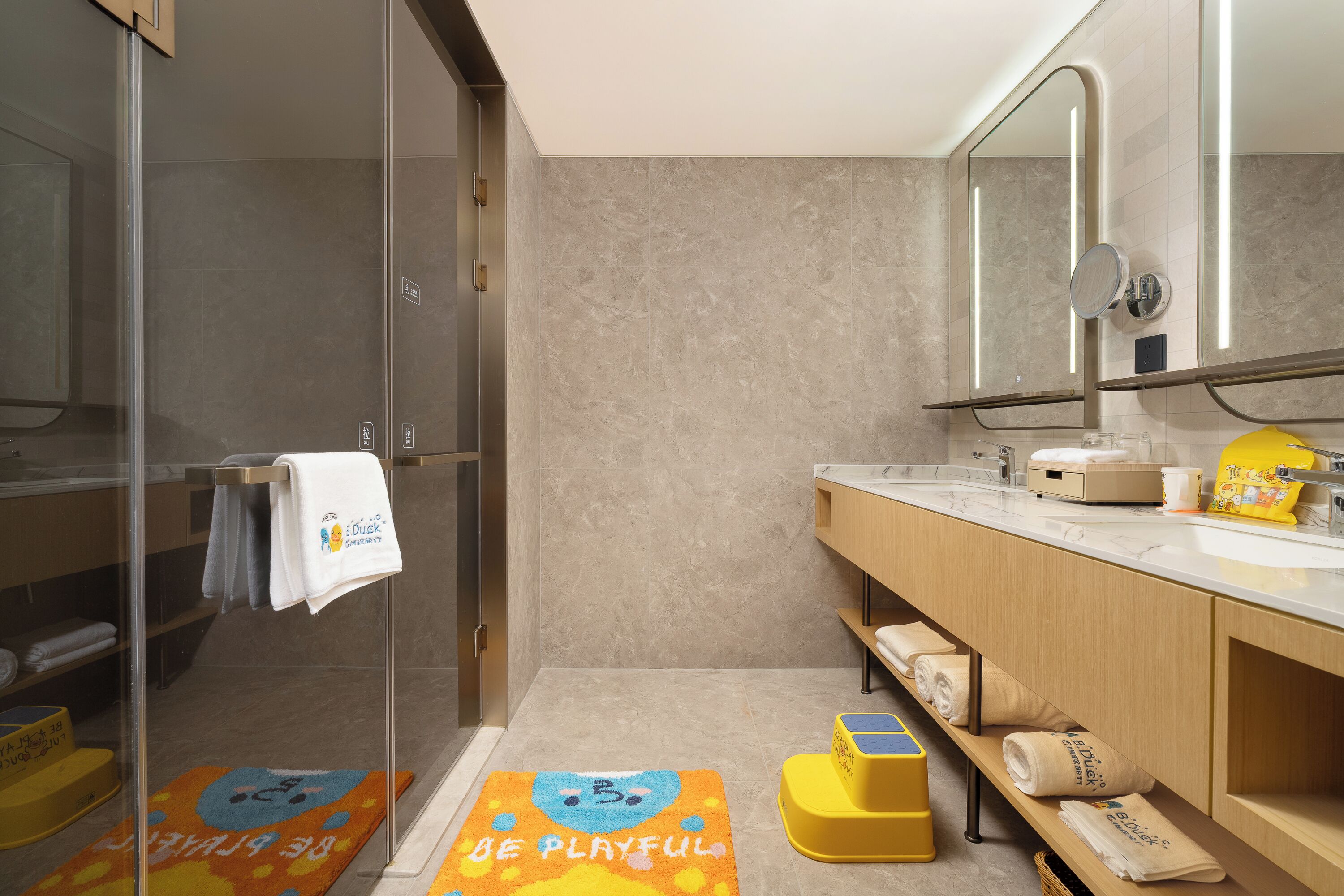 A modern bathroom with a glass shower enclosure, a wooden vanity with a mirror, and a towel rack.