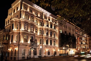 A multi-story building with illuminated signage reading "canopy" and a clock on the facade.