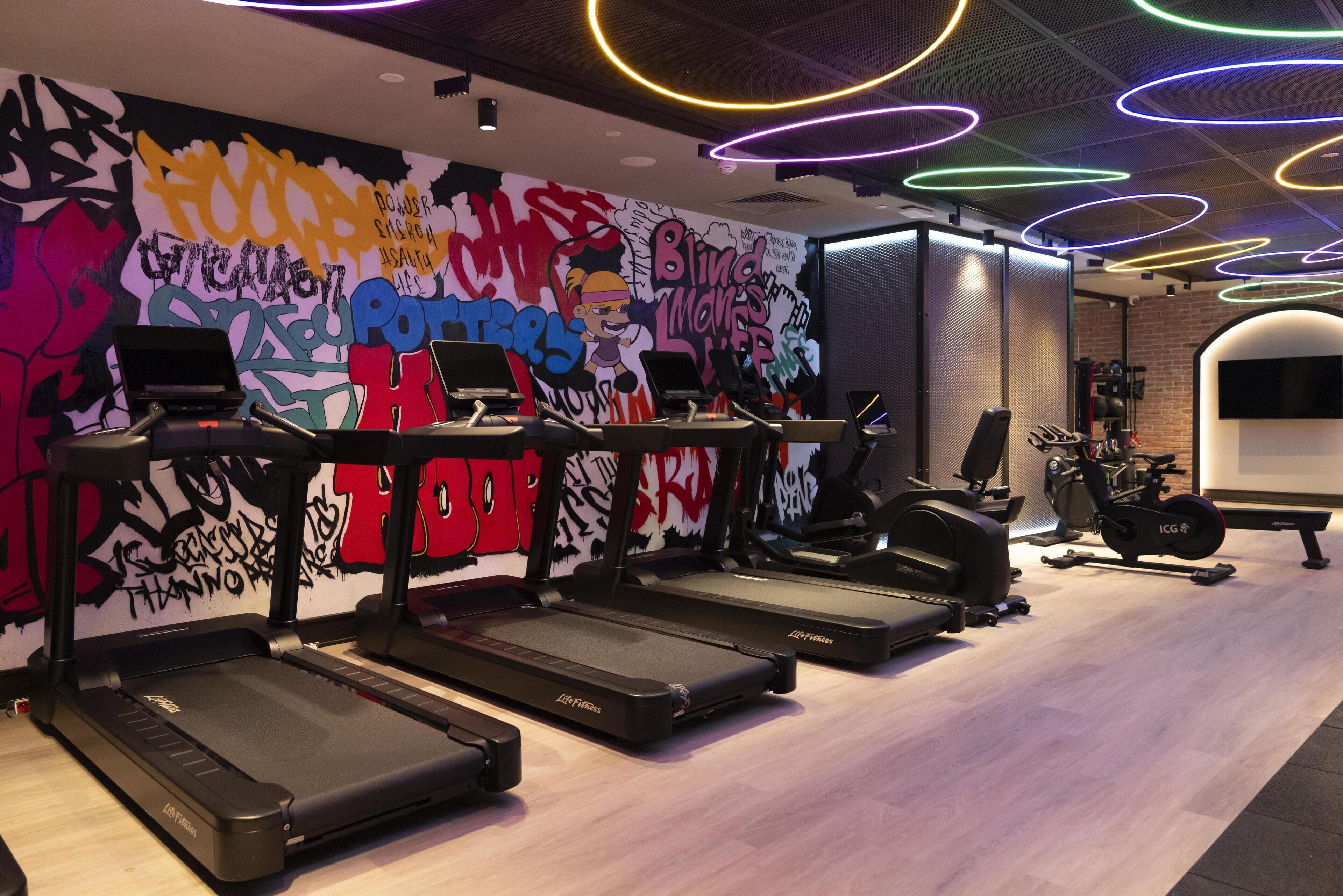 A gym with treadmills, an elliptical, and a stationary bike.