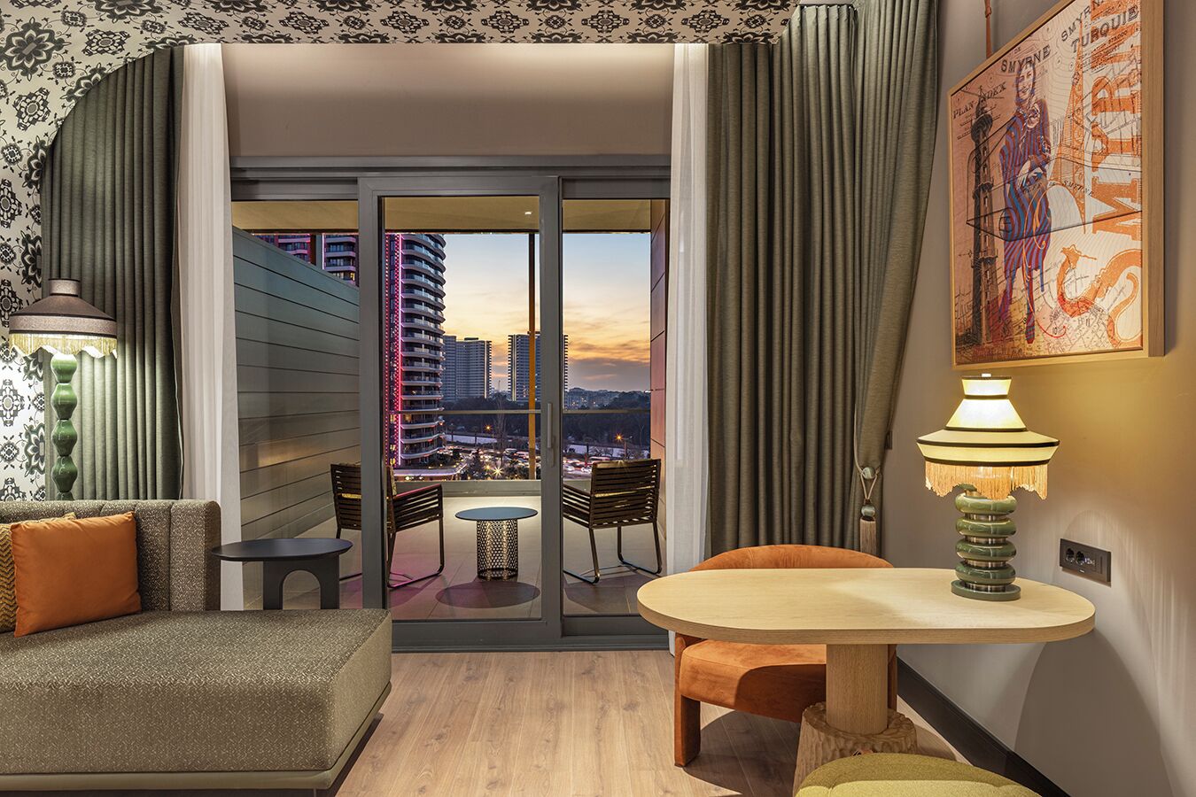 A modern hotel room with a balcony, a sofa, a small table, and a lamp.