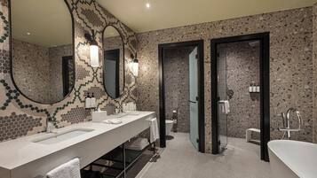 Un baño moderno con dos lavamanos, un espejo grande y una zona de ducha.