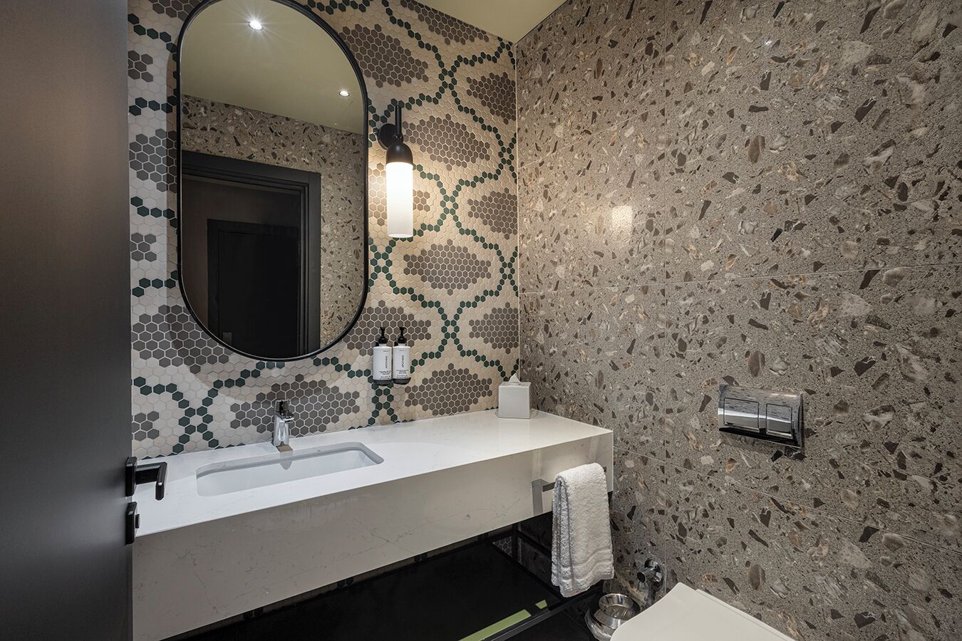 A bathroom with a white sink, a mirror, and a towel rack.