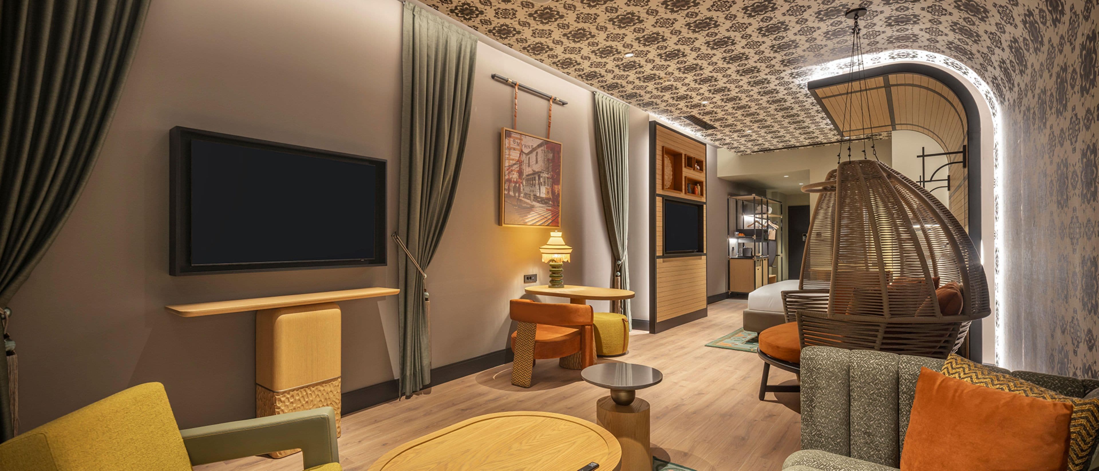 Habitación de hotel con televisión, zona de estar y comedor.