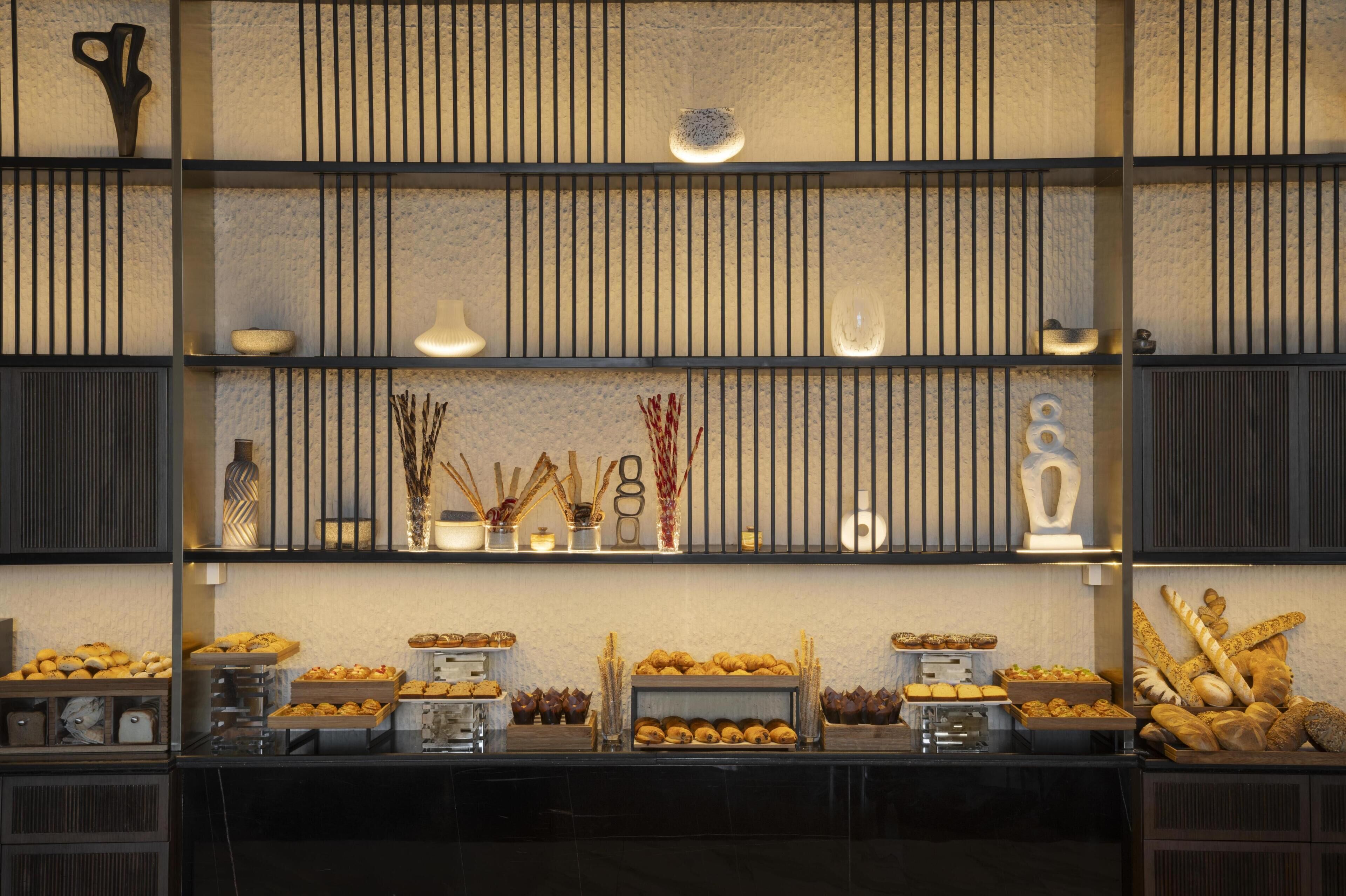 Un bufé con diversos alimentos y elementos decorativos sobre estantes.