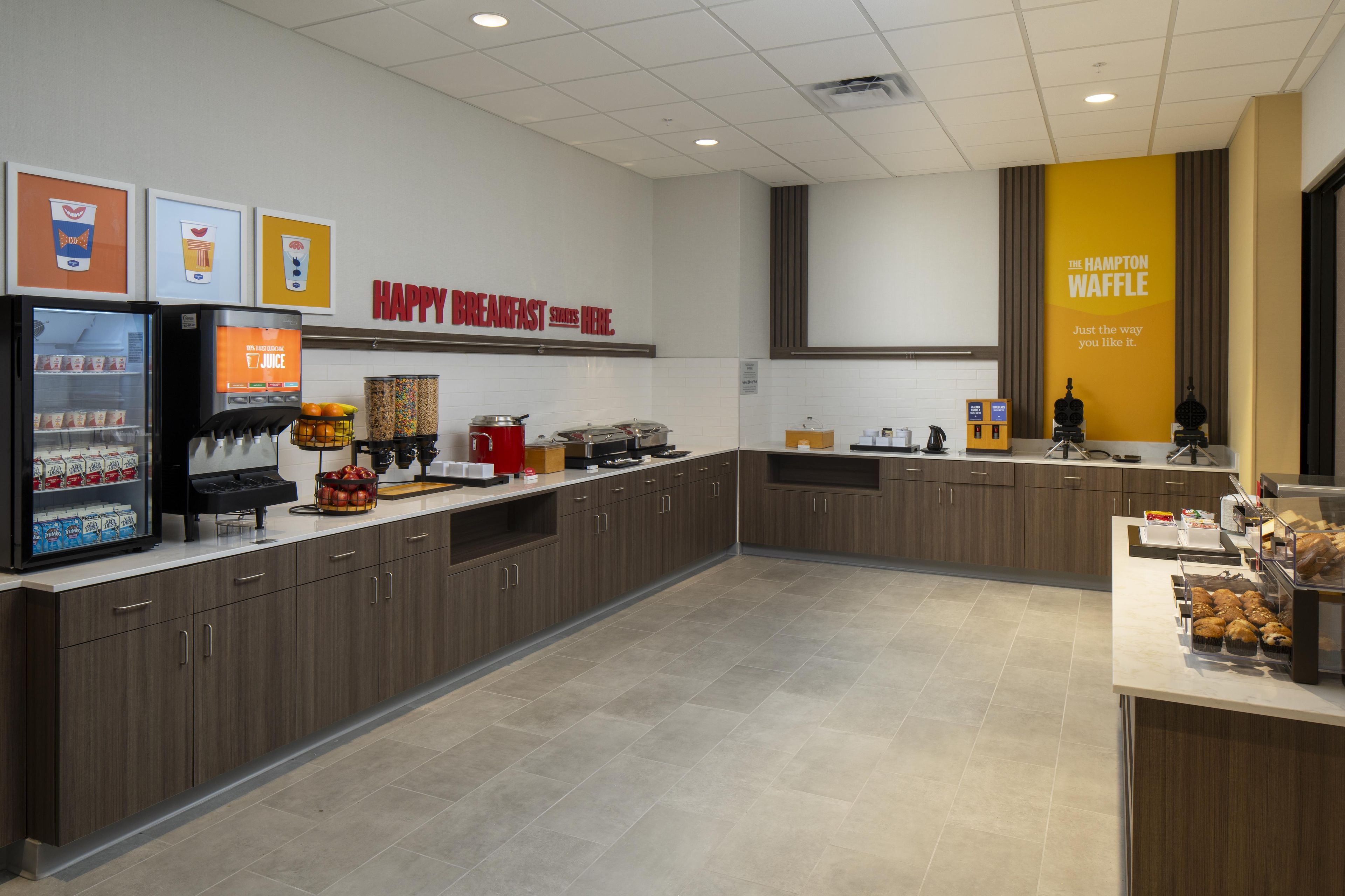 A breakfast area with a coffee machine, a refrigerator, and a waffle station.