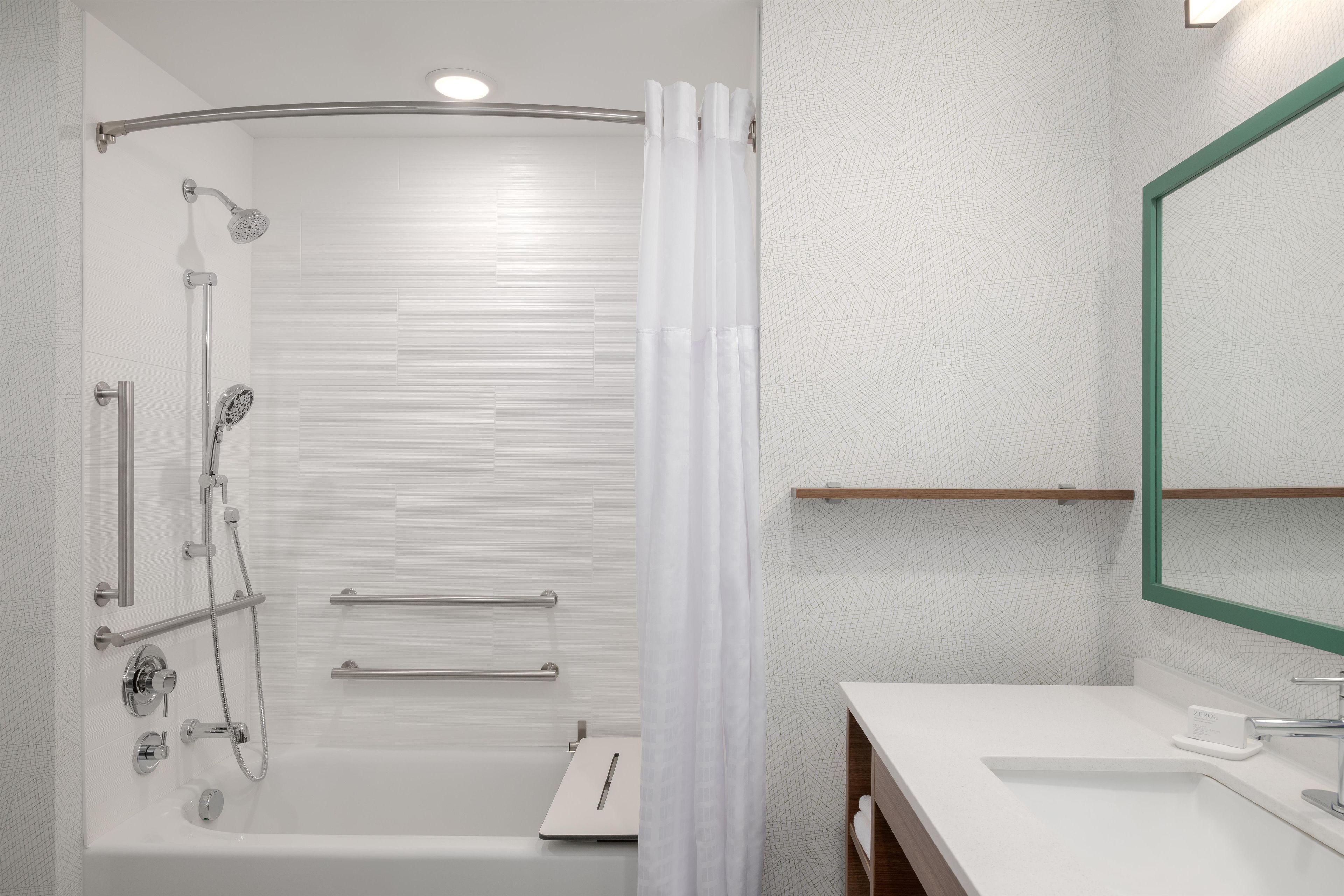 Ein modernes Badezimmer mit Badewanne, Dusche und Waschtisch mit Spiegel.