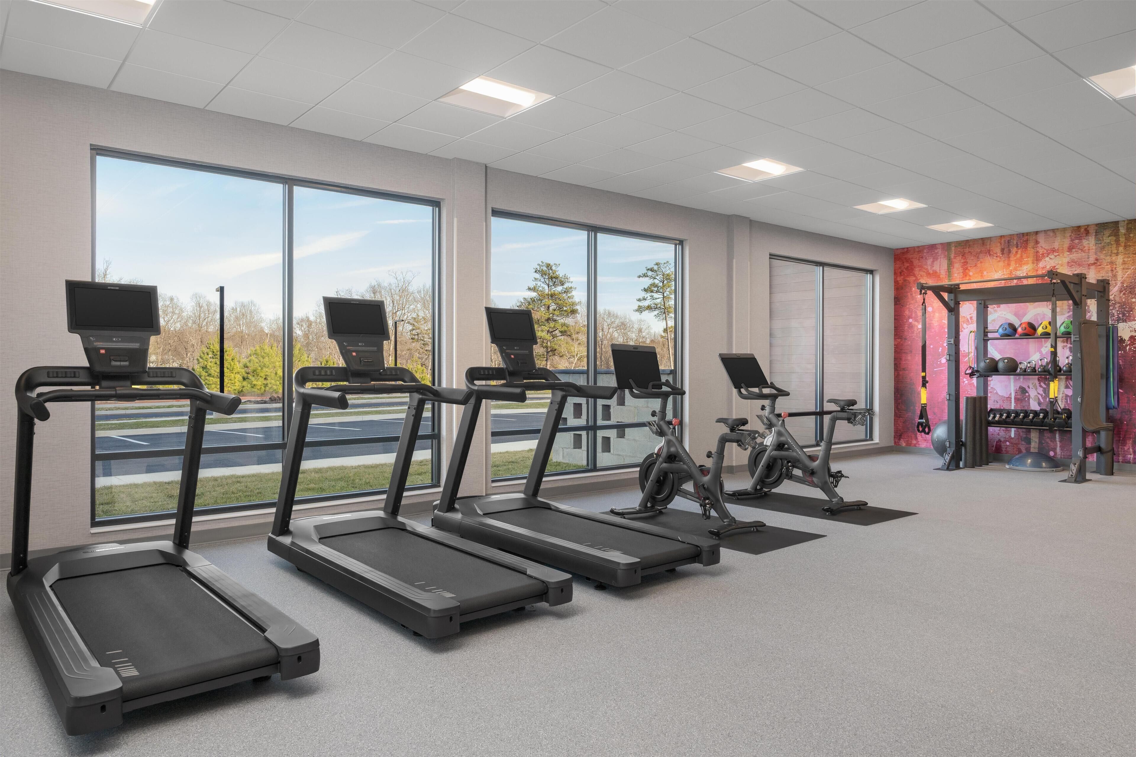 A gym with treadmills, an exercise bike, and a weightlifting area.