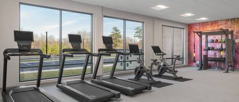 A gym with treadmills, an exercise bike, and a weight rack.