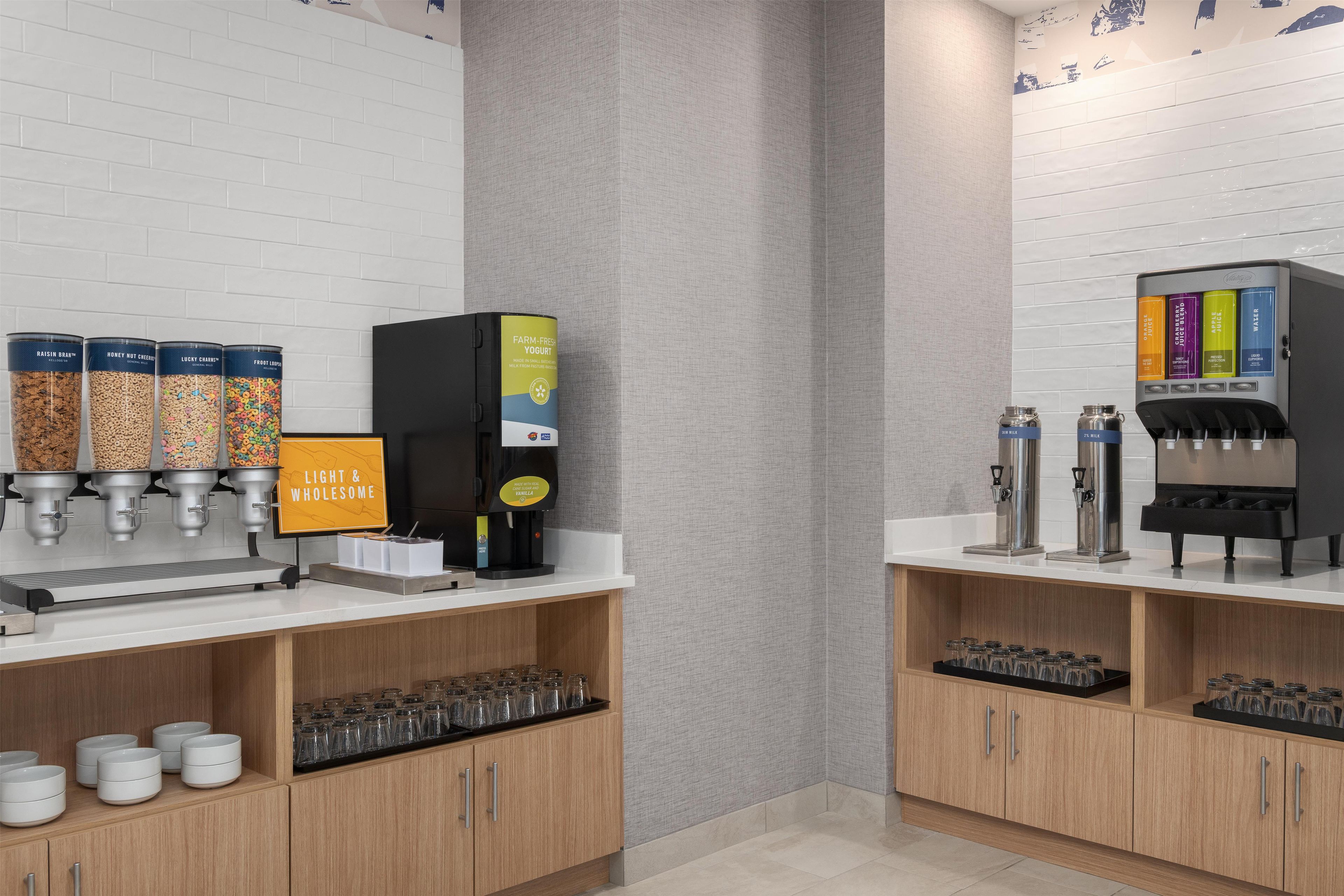 A beverage station with multiple dispensers, including options for milk, juice, and water.