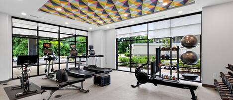 A gym with treadmills, weight machines, and exercise balls.