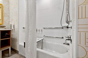 A modern bathroom with a bathtub, shower, and handrails. - Home2 Suites By Hilton Raleigh Crabtree (Raleigh)