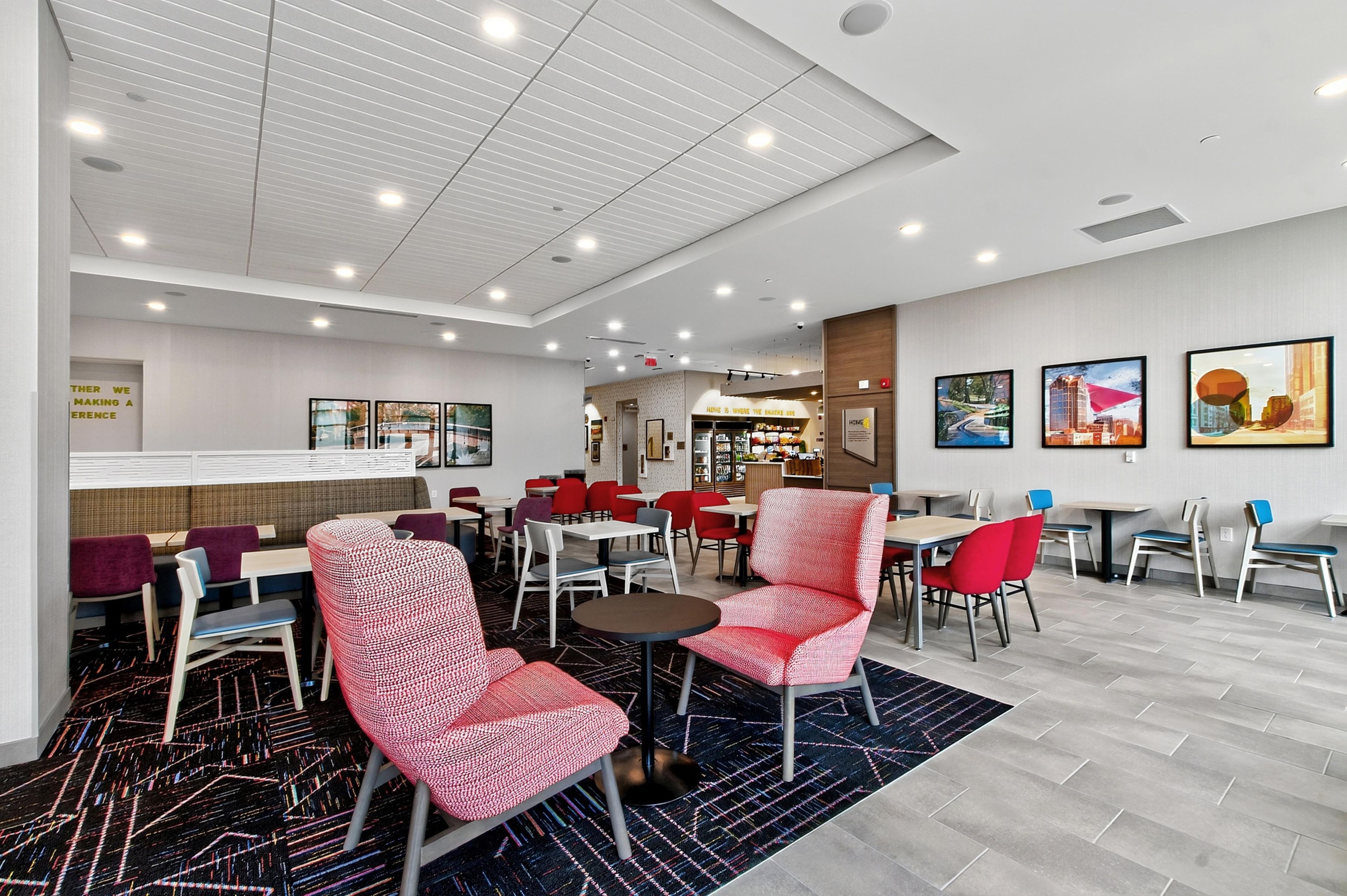 A hotel lobby with multiple seating areas, a bar, and a restaurant.