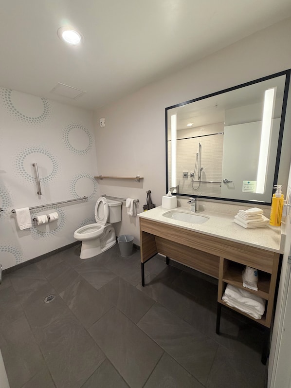 A modern bathroom with a toilet, bidet, sink, and mirror. - Tru By Hilton West Bristol Tn (Bristol)