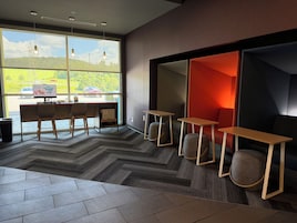 A modern office space with a desk, chairs, and a view of a parking lot.
