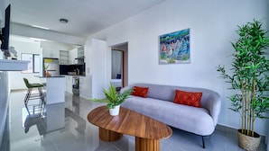 A modern living room with a sofa, a coffee table, and a potted plant. - Cozy Nest (La Romana)