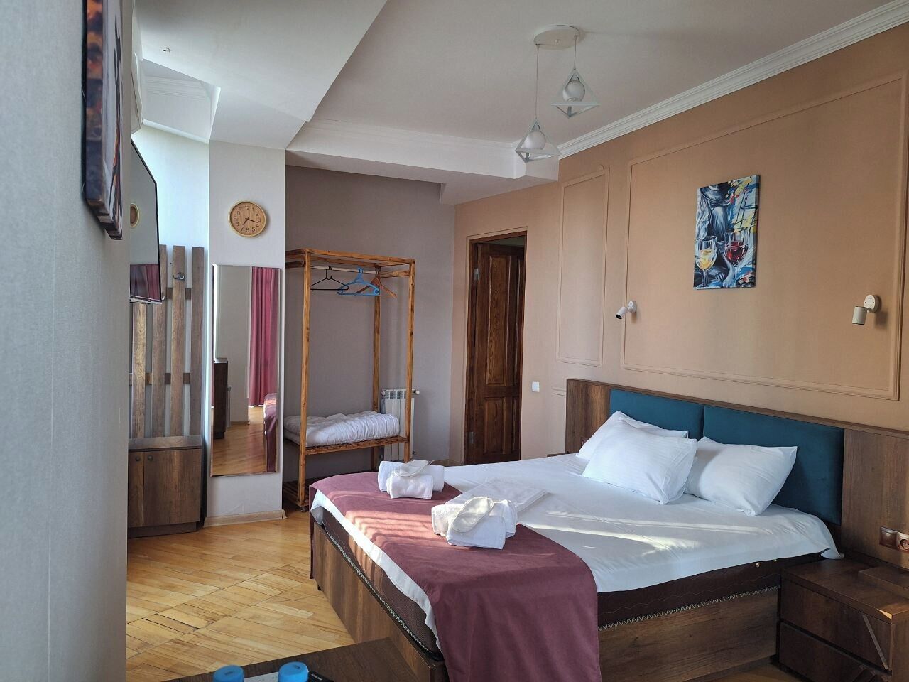 Ein Schlafzimmer mit einem Bett, einem Holzschrank, einem Hängekorbstuhl und einer Wanduhr.