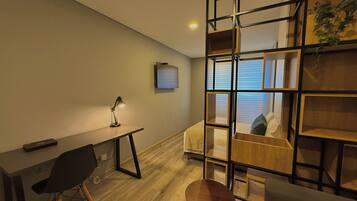 Un dormitorio moderno con escritorio, silla y cama con cabecera de madera.