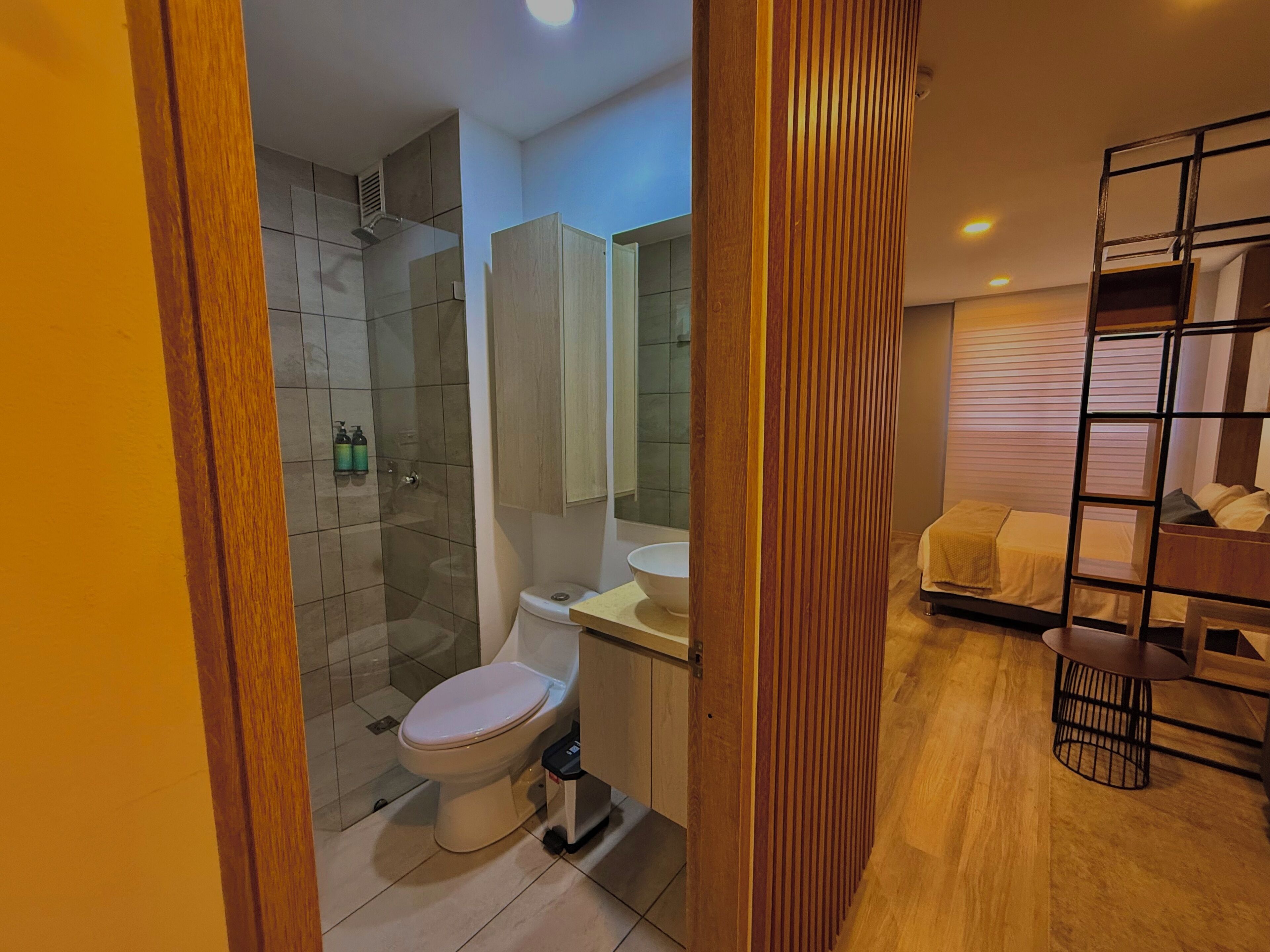 Un baño moderno con ducha acristalada, inodoro y lavamanos.
