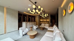 A modern lounge area with sofas, a coffee table, and a unique ceiling light fixture. - Modern Loft in 85st near Andino (Bogotá)